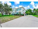 Charming two-story home featuring teal shutters, a well-manicured lawn, and an expansive driveway at 309 Black Springs Ln, Winter Garden, FL 34787