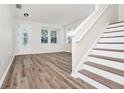 Bright living room featuring wood-look floors, neutral walls, windows, and staircase to the right at 309 Black Springs Ln, Winter Garden, FL 34787