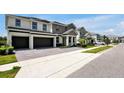 A stunning view of a two-story home displaying a three-car garage and manicured landscaping on a beautiful day at 3860 Sonoma Blvd, Kissimmee, FL 34741
