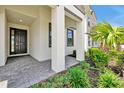 Covered front porch with gray stone walkway and lush landscaping at 3860 Sonoma Blvd, Kissimmee, FL 34741