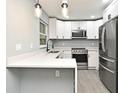 Beautiful kitchen features white cabinets, stainless steel appliances, quartz countertops, and a modern faucet at 5805 Hutton Dr, Orlando, FL 32808