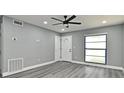 Welcoming living room featuring new gray vinyl floors, fresh paint, and contemporary ceiling fan at 5805 Hutton Dr, Orlando, FL 32808