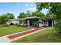 Cozy home with a welcoming front yard, lovely landscaping, and a red brick walkway at 6 S Lakewood Dr, Orlando, FL 32803