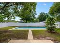Backyard showcasing a rectangular in-ground pool surrounded by a white fence and green lawn at 6 S Lakewood Dr, Orlando, FL 32803