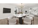 Open-concept dining room featuring a marble table, modern light fixture, and kitchen access at 612 Florida Ave, St Cloud, FL 34769