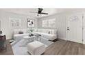 Bright living room with neutral tones featuring a white sofa, modern art, and a ceiling fan at 612 Florida Ave, St Cloud, FL 34769