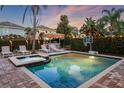 Backyard pool and hot tub with comfortable lounge furniture, a tiki bar, and lush landscaping at 640 Lasso Dr, Kissimmee, FL 34747