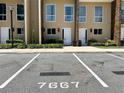 Contemporary townhome exterior featuring well-maintained landscaping and designated parking with clear marking at 7667 Recife Dr, Kissimmee, FL 34747