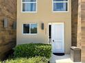 Inviting townhome exterior with a modern front door, manicured landscaping, and stylish light fixtures at 7667 Recife Dr, Kissimmee, FL 34747