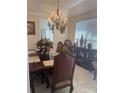 Formal dining room with elegant chandelier, large window, and tastefully decorated table setting at 802 Kaywood Dr, Orlando, FL 32825