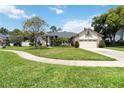 Inviting home featuring a well-kept lawn, mature trees, and a concrete walkway at 802 Kaywood Dr, Orlando, FL 32825