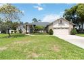 Well-maintained home featuring a green lawn, manicured landscaping, and mature trees at 802 Kaywood Dr, Orlando, FL 32825