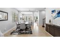 Bright dining room with modern table, rug, chandelier, and view to the living room and staircase at 8312 Prestbury Dr, Orlando, FL 32832