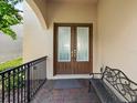 Front entryway has double doors with glass panes, and a wrought iron bench at 8312 Prestbury Dr, Orlando, FL 32832