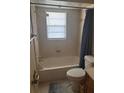 Standard bathroom with tiled walls, bathtub, shower, and toilet, awaiting renovation at 977 E Normandy Blvd, Deltona, FL 32725