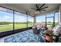 Inviting screened-in patio with comfortable seating, ceiling fan, and serene views of the lush backyard and lake at 15208 Lake Claire Overlook Dr, Winter Garden, FL 34787