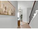 Inviting foyer with tile flooring, staircase, art, and modern light fixture at 15947 Vetta Dr, Bella Collina, FL 34756