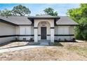 Inviting front entrance with a new door, complemented by fresh landscaping and windows at 1617 Hallcrest Dr, Deltona, FL 32725