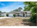 Beautifully landscaped single-story home with a two car garage, and a well-maintained yard at 1617 Hallcrest Dr, Deltona, FL 32725