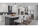 Elegant kitchen featuring a central island with seating, modern appliances, and sleek, white cabinetry at 1618 Bellagio Loop, Tavares, FL 32778