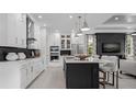 Modern kitchen with a center island, white cabinets, stainless steel appliances, and stylish pendant lighting at 1618 Bellagio Loop, Tavares, FL 32778
