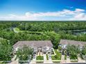 An aerial shot highlighting well-maintained townhomes near a serene lake and lush greenery at 1757 Sunset Palm Dr, Apopka, FL 32712