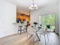 Bright dining room with a modern chandelier, table set, and kitchen bar at 1757 Sunset Palm Dr, Apopka, FL 32712