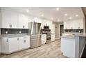 Modern kitchen featuring white cabinets, granite countertops, stainless steel appliances, and wood flooring at 2320 Wekiva Ridge Rd, Apopka, FL 32712