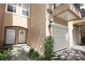 Inviting townhome entrance with a well-lit doorway, lovely floral wreath, and a manicured garden at 2493 Lancien Ct # 5, Orlando, FL 32826