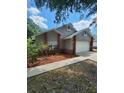 Cozy home with red brick details and a neatly mulched front garden at 2723 Talladega Dr, Orlando, FL 32826