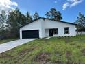 Charming single-story home features a black garage door and a well-manicured lawn at 3063 Sw 168Th Loop, Ocala, FL 34473