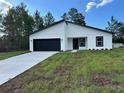 Charming single-story home features a black garage door and a well-manicured lawn at 3063 Sw 168Th Loop, Ocala, FL 34473