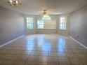 Spacious living room featuring neutral paint, tile flooring, and large windows for natural light at 3157 Britannia Blvd # B, Kissimmee, FL 34747