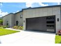 Modern home exterior features a sleek garage door, well-manicured lawn, and contemporary design at 346 Bowfin Ct, Kissimmee, FL 34759