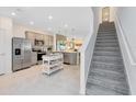 Modern kitchen featuring stainless steel appliances, center island and easy access to stairs at 3610 Raindrop Way, Sanford, FL 32773
