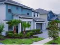 A row of modern homes showcases manicured lawns, palm trees, and contemporary gray and teal exterior color schemes at 3880 Sonoma Blvd, Kissimmee, FL 34741