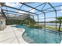 Gorgeous screened-in pool with spa, lush landscaping, and lake views, perfect for outdoor entertaining and relaxation at 4536 N Landmark Dr, Orlando, FL 32817