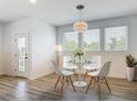 Bright dining area with modern round table, white chairs, stylish pendant lighting, and wood-look floors at 4630 Socrates Way, Sanford, FL 32773