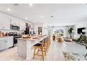Modern kitchen with granite countertops, stainless steel appliances, island with seating, and open to the living area at 4742 Yellow Elder Way, Kissimmee, FL 34758
