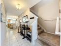 Bright entryway featuring tile flooring, a staircase, and views into the kitchen with barstool seating at 5420 Windsor Lake Cir, Sanford, FL 32773