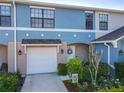 Townhome with attached garage, well-manicured flower beds, and covered porch for relaxing in comfort at 5420 Windsor Lake Cir, Sanford, FL 32773