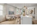 Well-designed kitchen island featuring pendant lighting, a dining area, and an open floor plan for modern living at 570 Hammock Oaks Blvd, Lady Lake, FL 32159