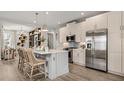 Open-concept kitchen with a spacious island, modern appliances, light wood cabinets, and stylish pendant lights at 570 Hammock Oaks Blvd, Lady Lake, FL 32159