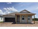 New home with an unfinished porch and an oversized garage at 5706 Cattle Ranch Drive, St Cloud, FL 34771