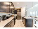 Modern kitchen featuring dark cabinetry, stainless steel appliances, and a center island with seating at 671 Drop Shot Dr, Davenport, FL 33896
