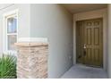 Inviting front entrance featuring stone accents, a green front door and a window at 7017 Oakwood St, Davenport, FL 33837