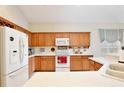 Well-lit kitchen with oak cabinets, white appliances, a microwave, and ample counter space at 9521 Southern Garden Cir, Altamonte Springs, FL 32714