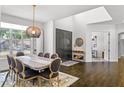 Bright dining room showcasing hardwood floors, a modern light fixture, and views of the front yard at 960 Brightwater Cir, Maitland, FL 32751