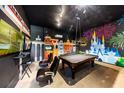 A cool game room has a pool table, arcade games, and chairs set against a mural wall at 970 Golden Bear Dr, Reunion, FL 34747