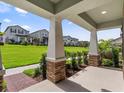 View from the home's covered patio showing a landscaped lawn and other neighborhood homes at 12009 Walmsley Aly, Winter Garden, FL 34787